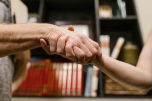 deux personnes qui échangent une poignée de mains décrivant une entente cordiale et bienveillante