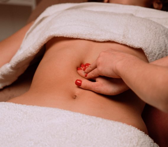 une femme se faisant masser le ventre par la méthode du drainage lymphatique manuel
